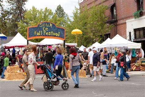 a picture of a fall festival with a crowd of people enjoying the event outside.