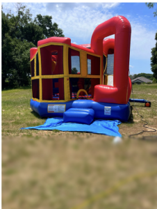 red, blue and yellow bounce house set up outside on sunny day